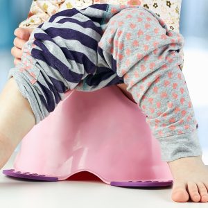 Children's Legs Hanging Down From A Chamber Pot