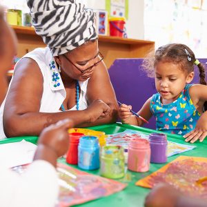 Teacher Sitting With Kids In A Preschool Class, Close Up