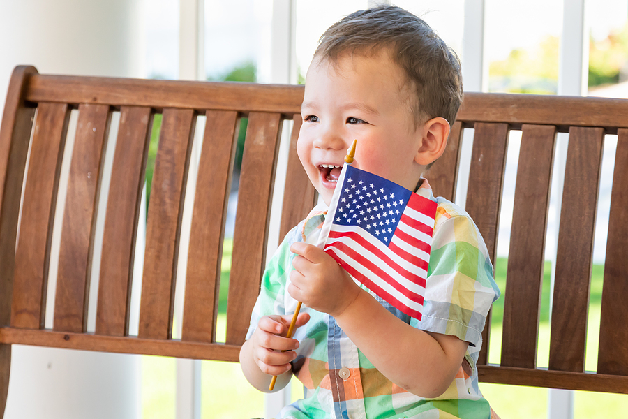 young mixed race chinese and caucasian boy playing with american