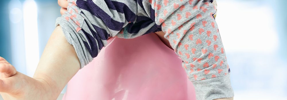 Children's Legs Hanging Down From A Chamber Pot