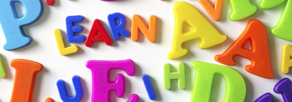 Macro composition of many colorful plastic toy letters and word