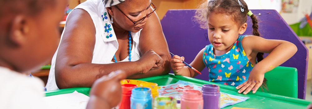 Teacher Sitting With Kids In A Preschool Class, Close Up